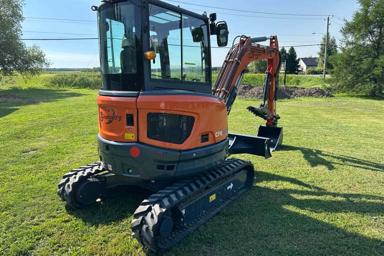 CFG-40UF mini excavator, rear three-quarter view showing rubber tracks and dozer blade, in a field